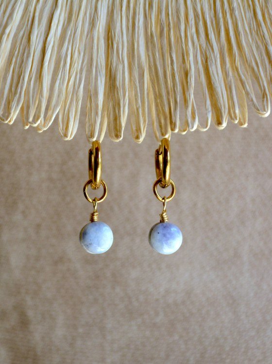 Aretes Belai Jade Lavanda Pequeño, argollas de acero con pequeño dije de piedra jade lavanda, apoyados sobre fibra de rafia y lino